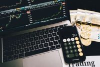 Ilustrasi seseorang tengah memegang koin Bitcoin virtual di depan grafik investasi yang menunjukkan fluktuasi harga. Ini menggambarkan pentingnya pemahaman pasar dan strategi matang dalam berinvestasi aset digital.