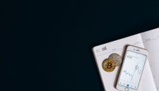 Ilustrasi tangan memegang koin Bitcoin virtual di depan grafik pertumbuhan pasar kripto yang menunjukkan potensi dan dinamika investasi aset digital. Gambar ini merepresentasikan peluang serta tantangan yang dihadapi para investor pemula di dunia Bitcoin.