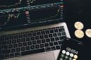 Seorang investor tengah menganalisis pergerakan grafik pasar kripto di laptopnya, mencoba memahami pola dan membuat keputusan investasi yang tepat di tengah fluktuasi harga. Suasana serius ini mencerminkan tantangan dan kompleksitas dalam berinvestasi di aset digital.