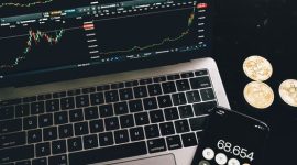 Seorang investor tengah menganalisis pergerakan grafik pasar kripto di laptopnya, mencoba memahami pola dan membuat keputusan investasi yang tepat di tengah fluktuasi harga. Suasana serius ini mencerminkan tantangan dan kompleksitas dalam berinvestasi di aset digital.