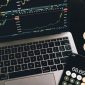 Seorang investor tengah menganalisis pergerakan grafik pasar kripto di laptopnya, mencoba memahami pola dan membuat keputusan investasi yang tepat di tengah fluktuasi harga. Suasana serius ini mencerminkan tantangan dan kompleksitas dalam berinvestasi di aset digital.