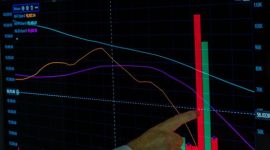 Grafik harga mata uang kripto yang berfluktuasi tajam di layar ponsel menggambarkan tingginya risiko dan ketidakpastian dalam investasi aset digital. Investor perlu memahami dinamika pasar ini agar tidak terjebak dalam kerugian finansial yang besar.