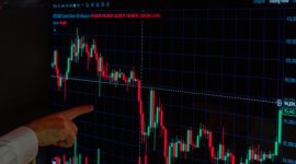 Seorang investor memantau grafik pergerakan harga aset kripto di layar, menggambarkan dinamika pasar digital yang menawarkan potensi keuntungan sekaligus tantangan. Gambar ini merefleksikan pentingnya analisis data dalam pengambilan keputusan investasi di dunia kripto yang terus berkembang pesat.