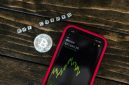 Ilustrasi tangan memegang koin Bitcoin digital yang bersinar di tengah grafik tren pasar kripto yang dinamis, melambangkan peluang dan tantangan bagi investor pemula. Gambar ini merepresentasikan potensi pertumbuhan aset digital dalam lanskap keuangan modern yang terus berubah.