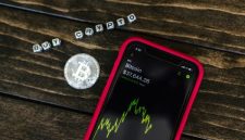 Ilustrasi tangan memegang koin Bitcoin digital yang bersinar di tengah grafik tren pasar kripto yang dinamis, melambangkan peluang dan tantangan bagi investor pemula. Gambar ini merepresentasikan potensi pertumbuhan aset digital dalam lanskap keuangan modern yang terus berubah.